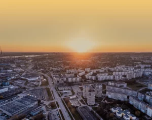 Aerial view of highways and industrial warehouses at sunrise, representing a complex logistics network for freight spend analysis.