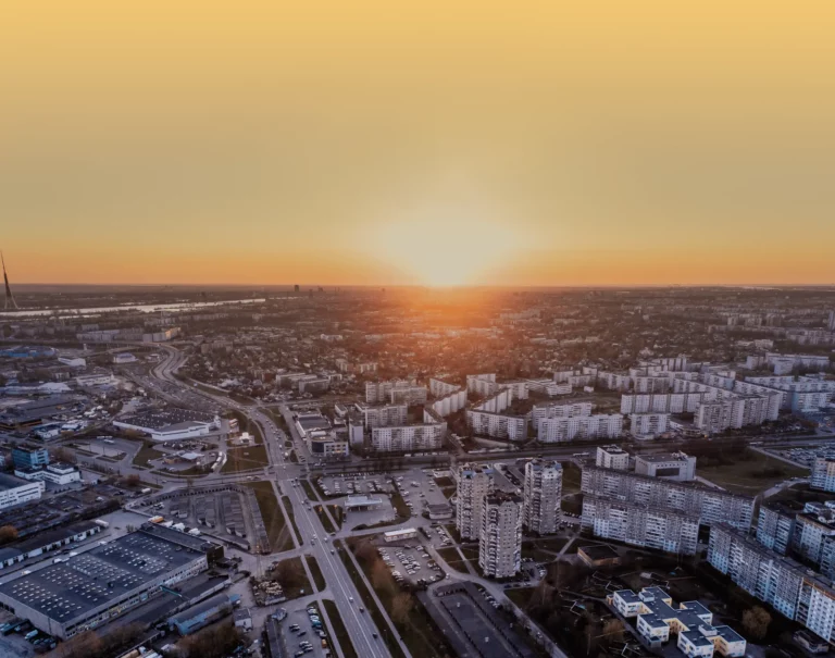 Aerial view of highways and industrial warehouses at sunrise, representing a complex logistics network for freight spend analysis.