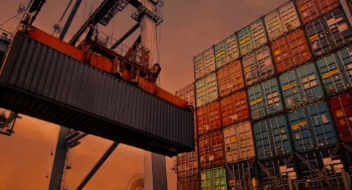 A large port crane lifting a shipping container, representing the complex logistics networks where hidden freight billing errors occur.