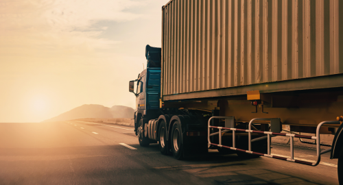 Truck driving into sunset