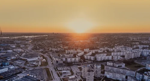 Aerial view of highways and industrial warehouses at sunrise, representing a complex logistics network for freight spend analysis.